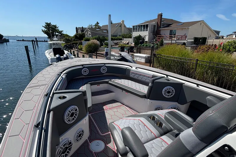 Slide: The Image of 2023 Fountain 34 SC boat interior with luxurious seating, speakers, and waterfront view. - 16
