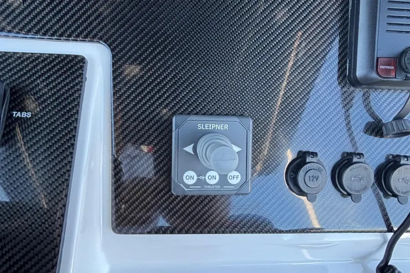 Slide: The Image of Control panel of 2023 Fountain 34 SC boat with carbon fiber finish and switches. - 23