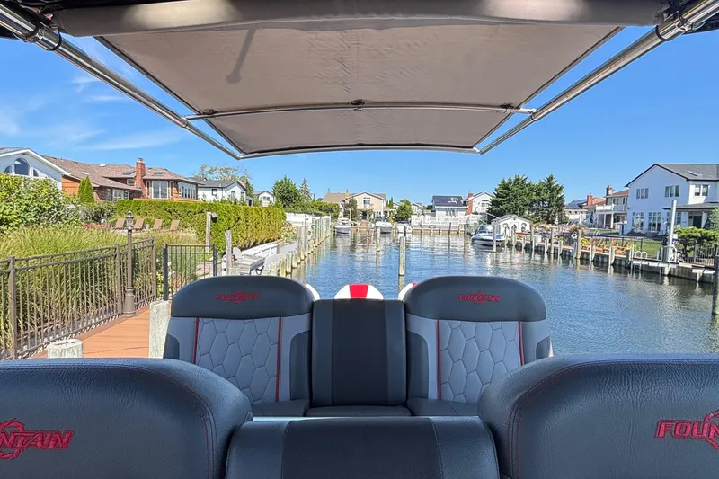 Slide: The Image of 2023 Fountain 34 SC boat docked in a scenic residential canal setting. - 26