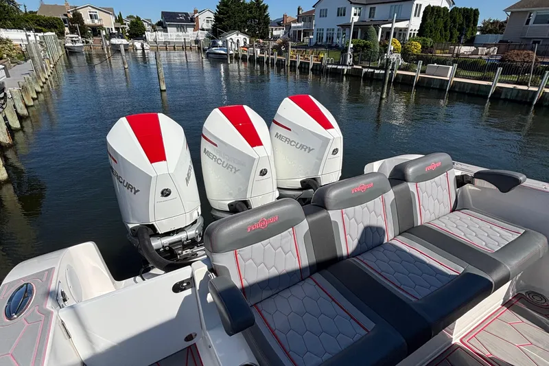 Slide: The Image of 2023 Fountain 34 SC boat with triple Mercury engines docked in a residential canal. - 30