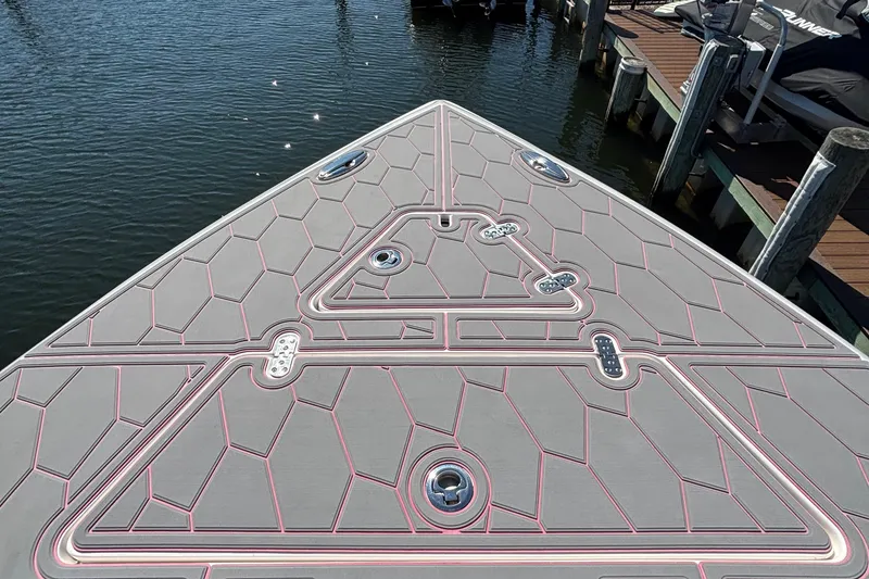 Slide: The Image of 2023 Fountain 34 SC boat deck with geometric pattern, docked by the water. - 41