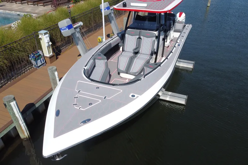 Slide: The Image of 2023 Fountain 34 SC boat docked, featuring sleek design and modern seating. - 49