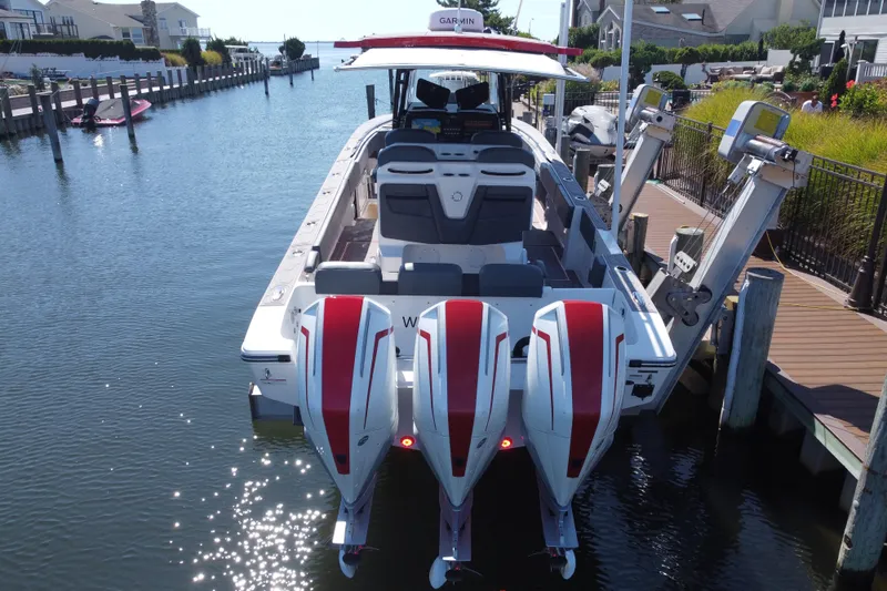 Slide: The Image of 2023 Fountain 34 SC boat with triple engines docked in a scenic marina. - 51