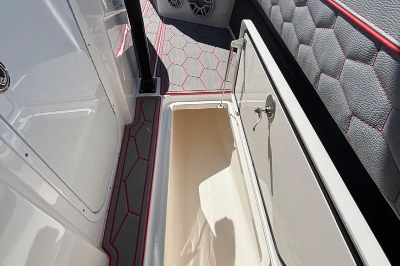 Slide: The Image of 2023 Fountain 34 SC boat interior with open storage compartment and hexagonal pattern flooring. - 58