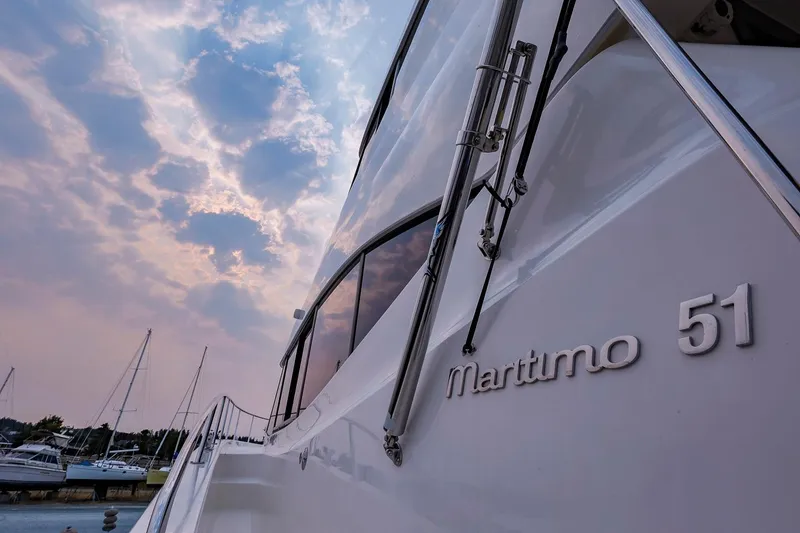 Slide: The Image of 2017 Maritimo M 51 yacht with cloudy sky and marina background. - 12