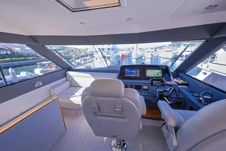Slide: The Image of 2017 Maritimo M 51 yacht interior with modern helm, navigation screens, and plush seating. - 17
