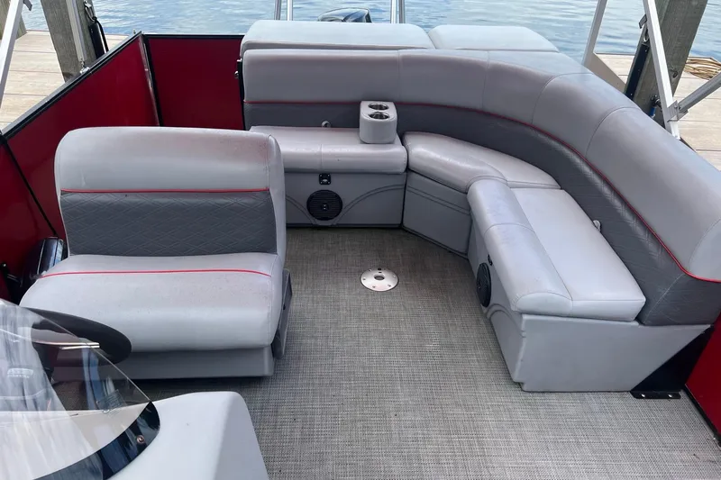 Slide: The Image of 2019 Bentley Pontoons 243 Cruise interior with gray seating and red accents on a pontoon boat. - 11