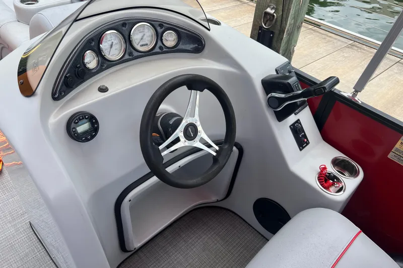 Slide: The Image of 2019 Bentley Pontoons 243 Cruise dashboard with steering wheel and control panel. - 12