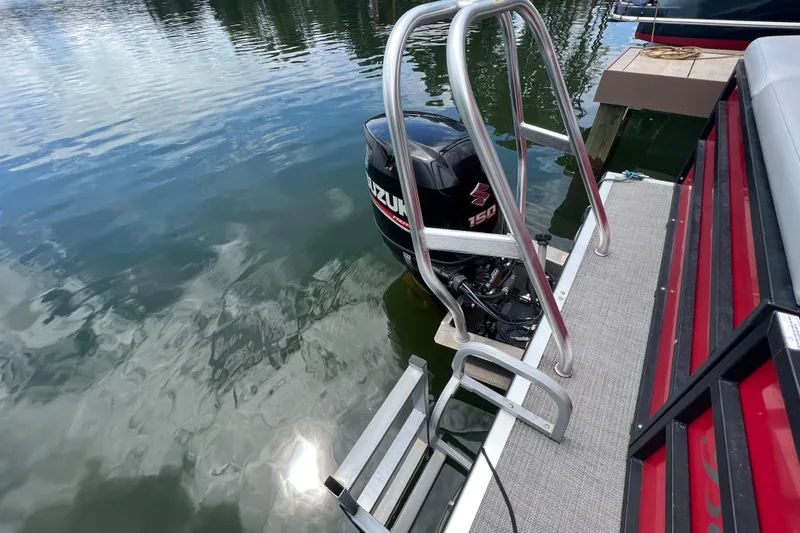 Slide: The Image of 2019 Bentley Pontoons 243 Cruise with Suzuki 150 engine and swim ladder on a calm lake. - 3