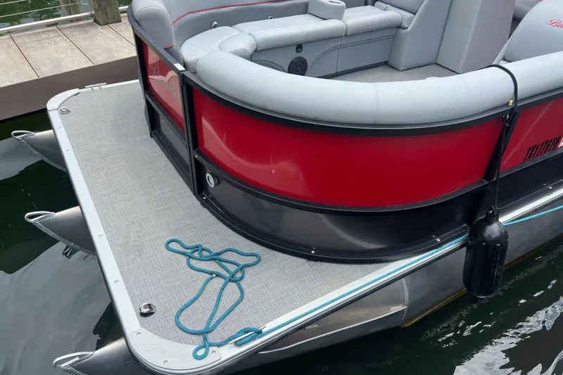 Slide: The Image of 2019 Bentley Pontoons 243 Cruise boat with red and gray seating, docked on water. - 6
