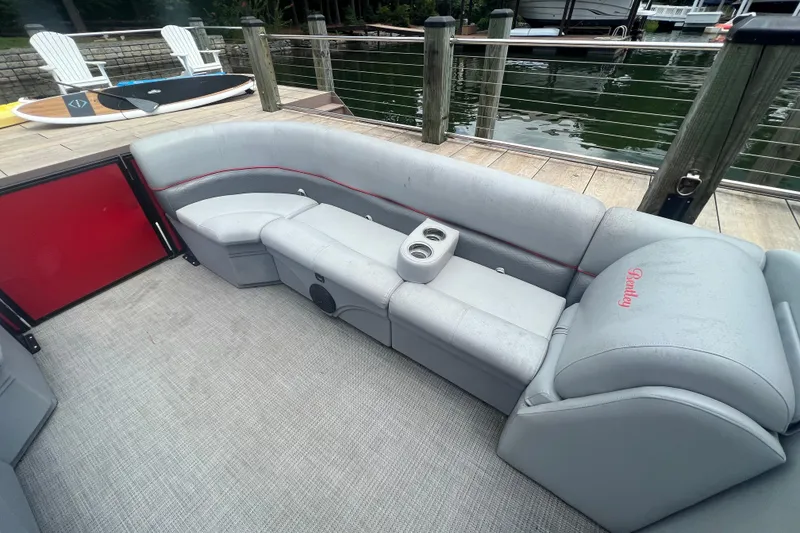 Slide: The Image of 2019 Bentley Pontoons 243 Cruise interior with gray seating and cup holders by a dock. - 8