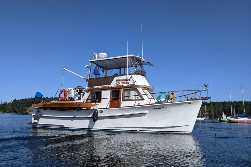 The Image of 1988 Monk 36 Aft Cabin boat on calm water, clear sky background. - 0