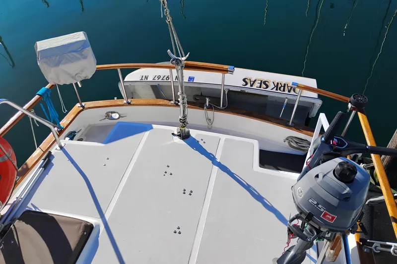 Slide: The Image of 1988 Monk 36 Aft Cabin boat deck with motor and railing, docked on calm water. - 19