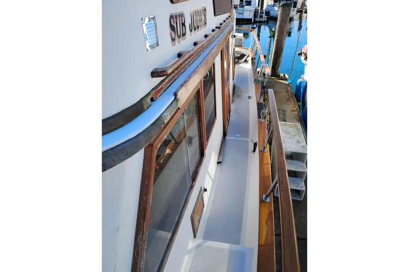 Slide: The Image of 1988 Monk 36 Aft Cabin boat deck with wooden railings and dock view. - 21
