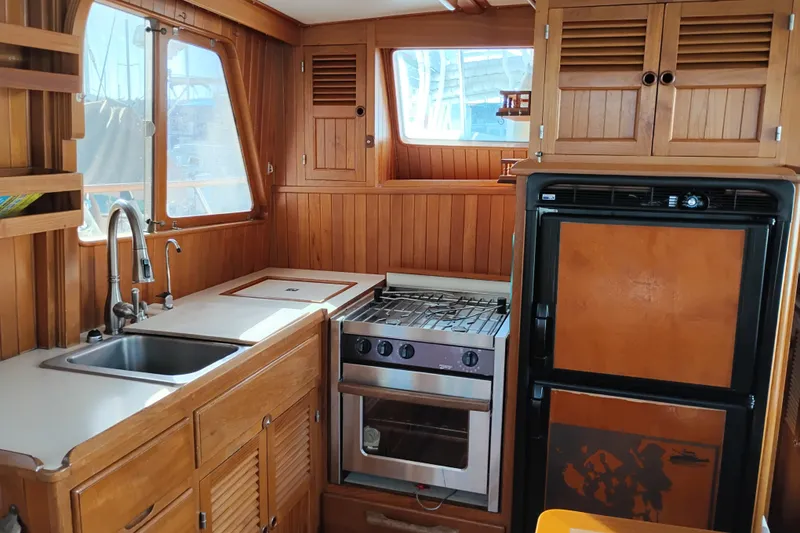 Slide: The Image of 1988 Monk 36 Aft Cabin kitchen with wood cabinetry, stove, and sink. - 23