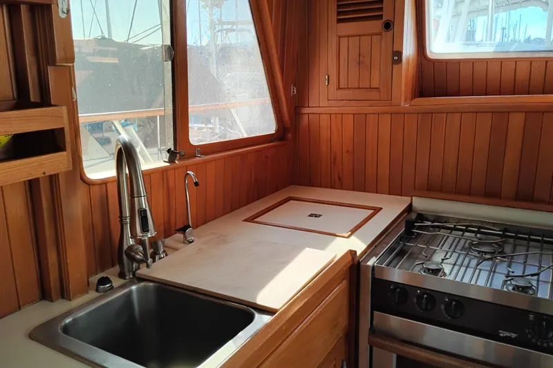 Slide: The Image of 1988 Monk 36 Aft Cabin kitchen with wood paneling, sink, and stove. - 24