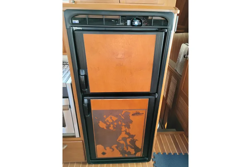 Slide: The Image of 1988 Monk 36 Aft Cabin refrigerator with wooden paneling and map design. - 28