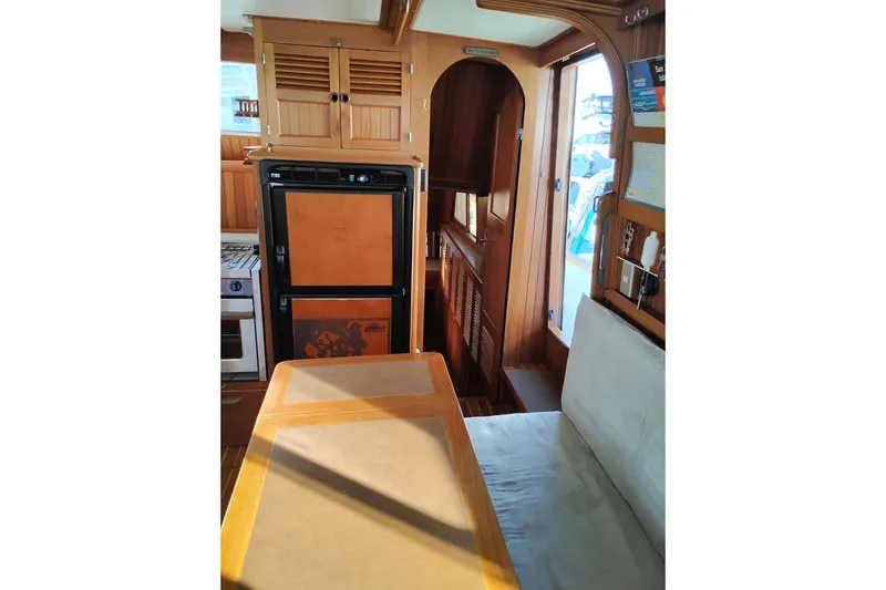 Slide: The Image of 1988 Monk 36 Aft Cabin interior with wood finish, dining area, and kitchen appliances. - 30