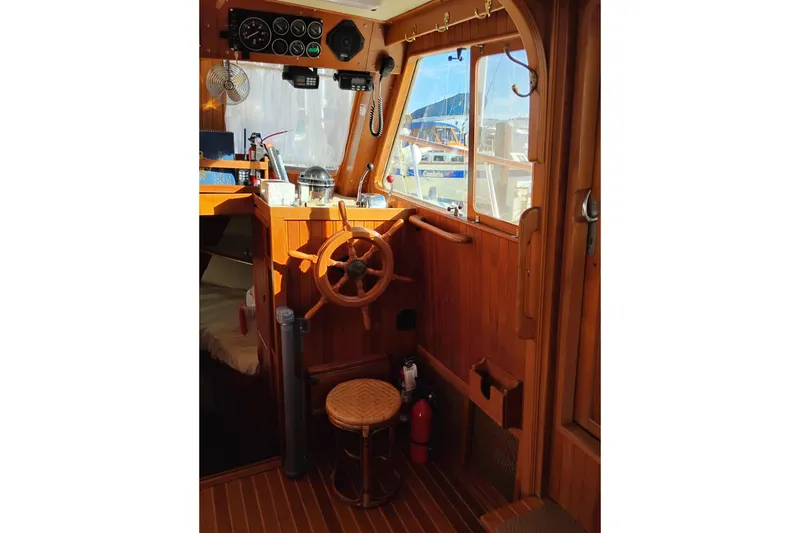 Slide: The Image of 1988 Monk 36 Aft Cabin interior with wooden helm and nautical instruments. - 31