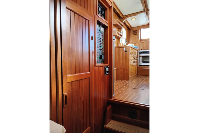 Slide: The Image of 1988 Monk 36 Aft Cabin interior with wood paneling and kitchen area. - 37