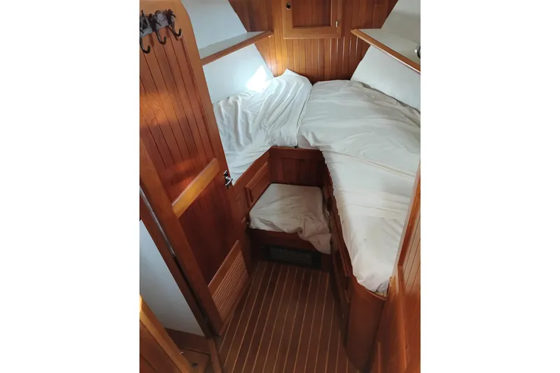 Slide: The Image of 1988 Monk 36 Aft Cabin interior with wooden paneling and cozy bed setup. - 38