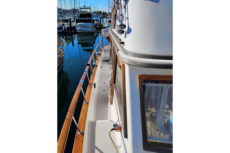 Slide: The Image of 1988 Monk 36 Aft Cabin boat docked, showcasing wooden railings and marina view. - 4