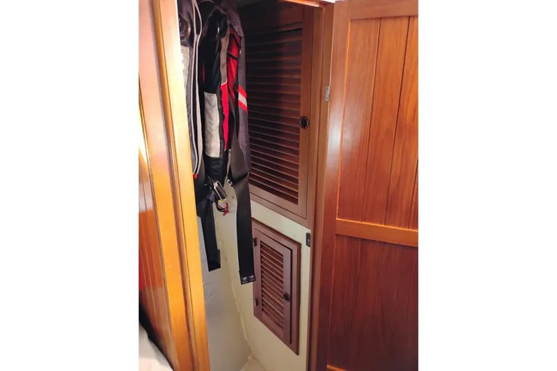 Slide: The Image of Wooden closet interior on 1988 Monk 36 Aft Cabin boat, featuring hanging clothes. - 40