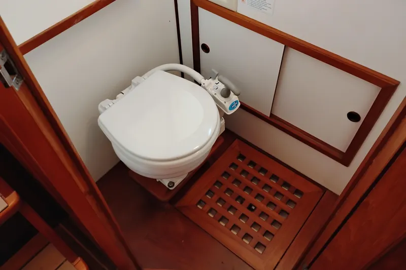 Slide: The Image of 1988 Monk 36 Aft Cabin bathroom with marine toilet and wooden flooring. - 41
