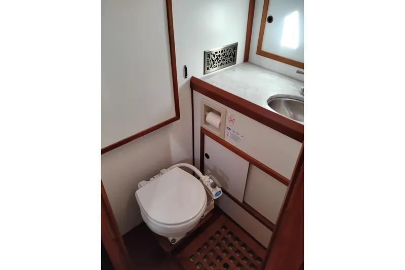 Slide: The Image of 1988 Monk 36 Aft Cabin bathroom with toilet, sink, and storage cabinets. - 42