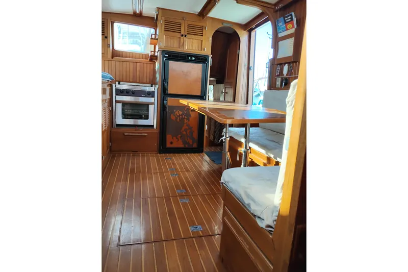 Slide: The Image of 1988 Monk 36 Aft Cabin interior with wood finish, kitchen, and dining area. - 44