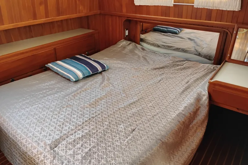 Slide: The Image of 1988 Monk 36 Aft Cabin interior with bed, wooden walls, and striped pillow. - 46