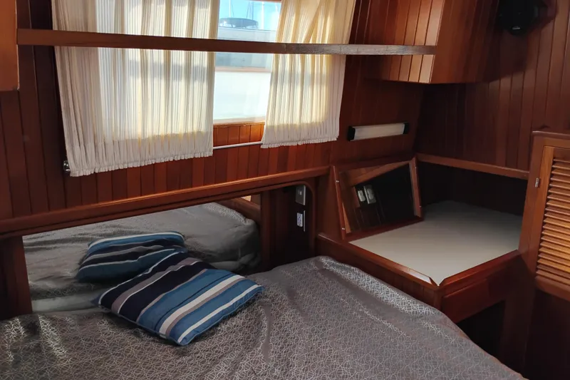 Slide: The Image of 1988 Monk 36 Aft Cabin interior with wood paneling and cozy bedding. - 48