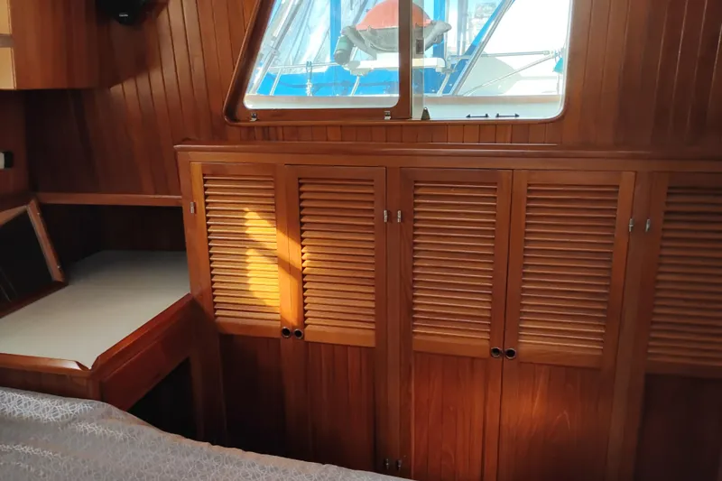 Slide: The Image of 1988 Monk 36 Aft Cabin interior with wooden cabinetry and window view. - 49