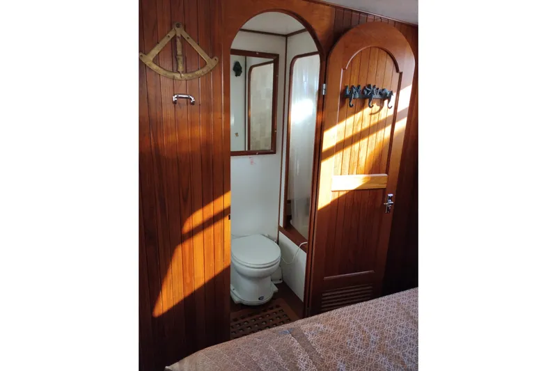 Slide: The Image of 1988 Monk 36 Aft Cabin bathroom with wooden doors and nautical decor. - 50
