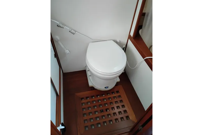 Slide: The Image of 1988 Monk 36 Aft Cabin bathroom with white toilet and wooden flooring. - 53