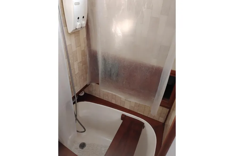 Slide: The Image of 1988 Monk 36 Aft Cabin shower with wood accents and tiled walls. - 54