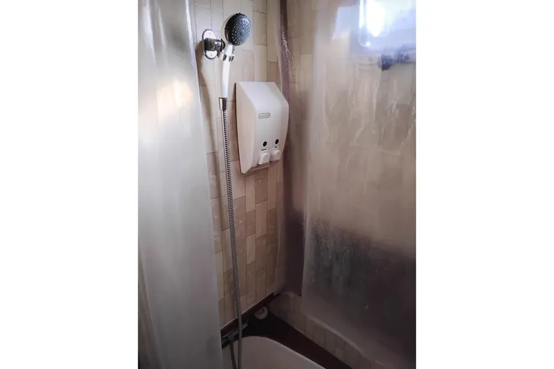Slide: The Image of Shower area in 1988 Monk 36 Aft Cabin boat with handheld showerhead and dispenser. - 56