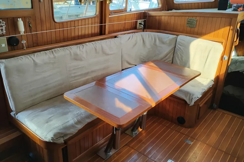 Slide: The Image of 1988 Monk 36 Aft Cabin interior with wooden dining area and cushioned seating. - 57