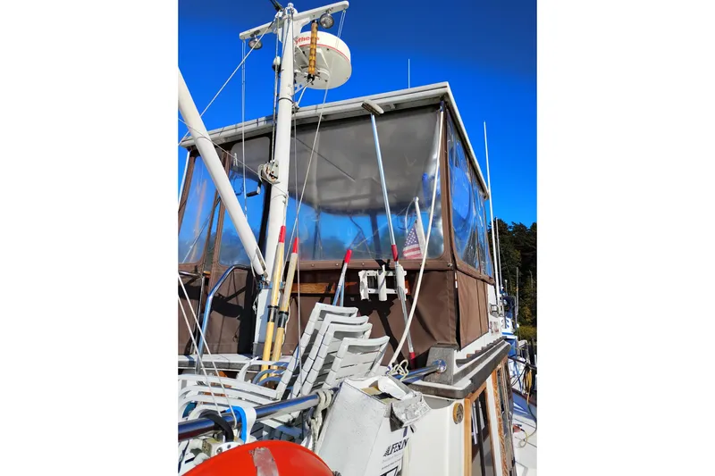 Slide: The Image of 1988 Monk 36 Aft Cabin boat with deck chairs and equipment under clear blue sky. - 6