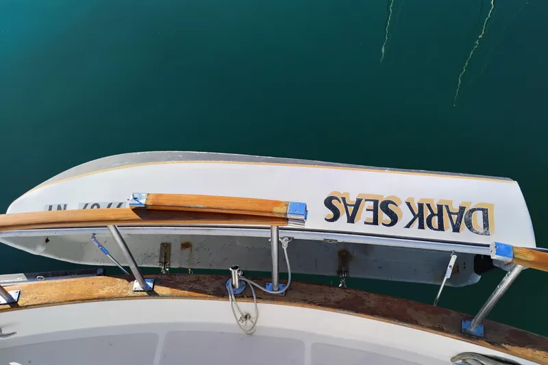 Slide: The Image of 1988 Monk 36 Aft Cabin boat with "Dark Seas" dinghy, docked on calm water. - 66