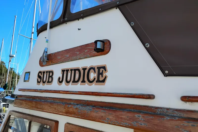 Slide: The Image of 1988 Monk 36 Aft Cabin boat named "Sub Judice" with wooden accents and brown canopy. - 69