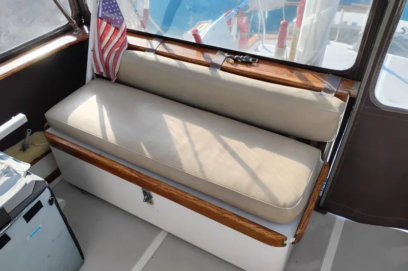 Slide: The Image of 1988 Monk 36 Aft Cabin interior with cushioned seating and American flag. - 9