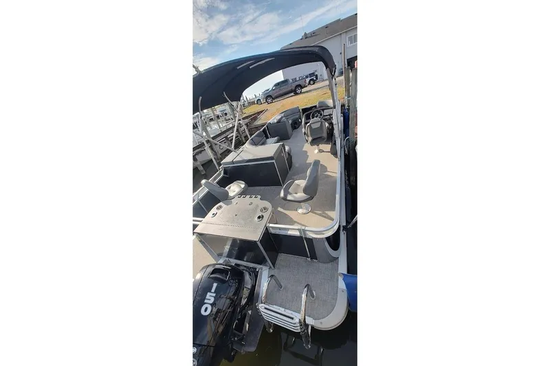 Slide: The Image of 2023 Tahoe Pontoon LTZ Entertainer with seating and canopy, docked by the water. - 12
