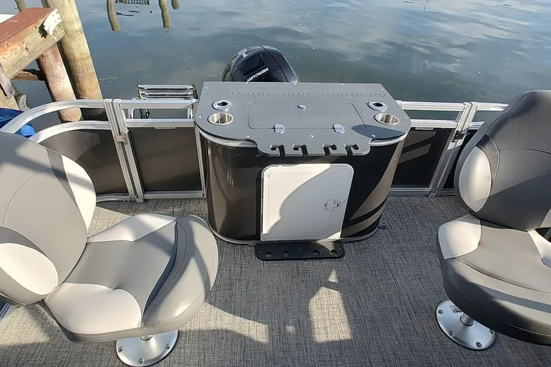 Slide: The Image of 2023 Tahoe Pontoon LTZ Entertainer interior with seating and bar setup on water. - 5