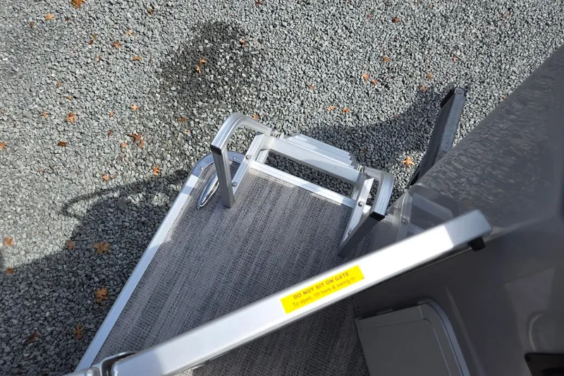 Slide: The Image of 2026 Godfrey Sweetwater 2286 FS boat gate and steps on gravel surface. - 29