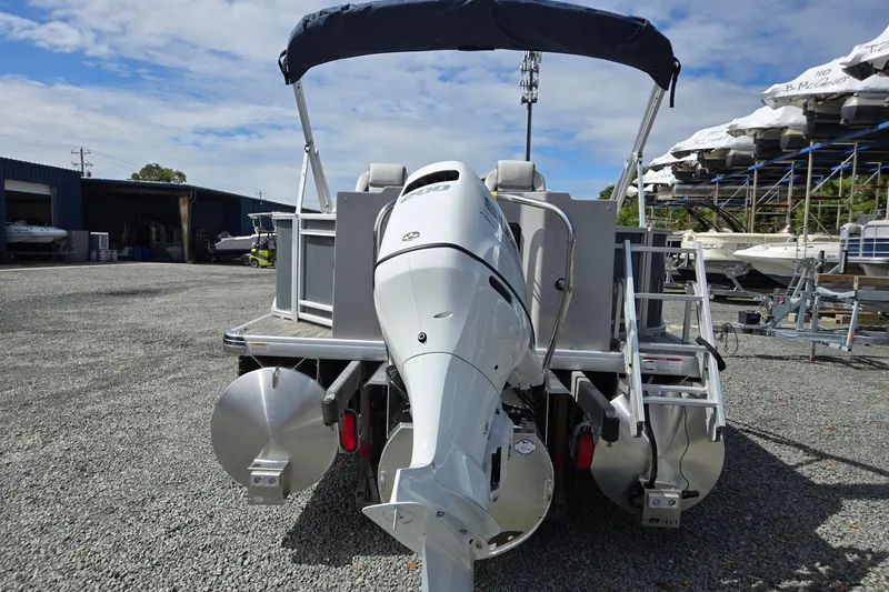 Slide: The Image of 2026 Godfrey Sweetwater 2286 FS pontoon boat with outboard motor, parked on gravel. - 4