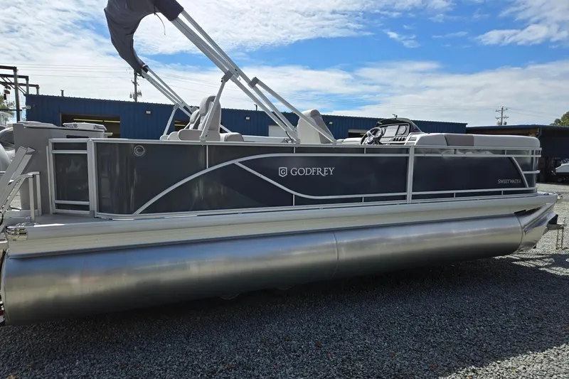 Slide: The Image of 2026 Godfrey Sweetwater 2286 FS pontoon boat on gravel lot under blue sky. - 6
