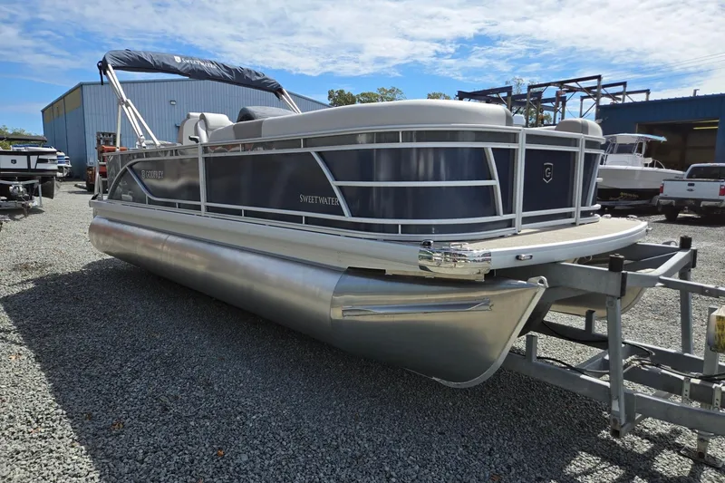 Slide: The Image of 2026 Godfrey Sweetwater 2286 FS pontoon boat on trailer, parked outdoors. - 8