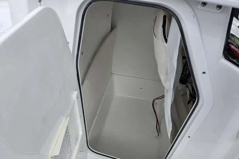 Slide: The Image of Interior storage compartment of 2026 Sea Hunt Ultra 229 boat, featuring white finish and wiring. - 21