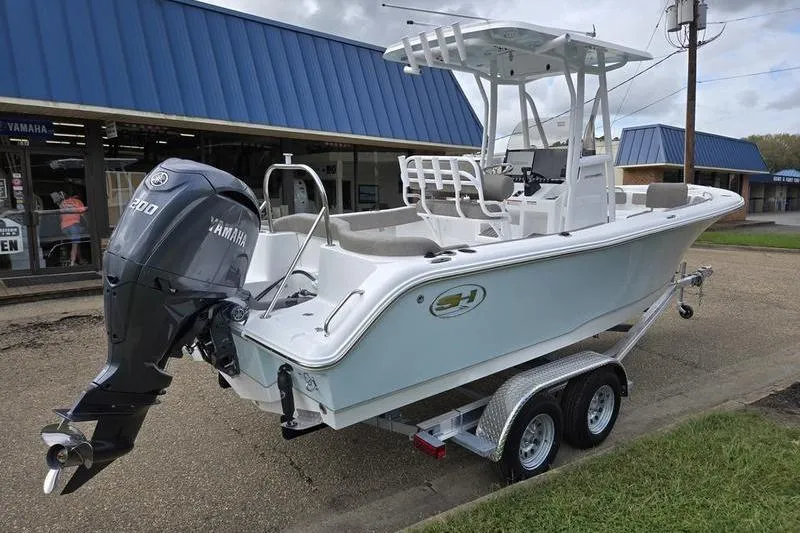 Slide: The Image of 2026 Sea Hunt Ultra 229 boat on trailer, featuring Yamaha 200 engine, parked outside dealership. - 5